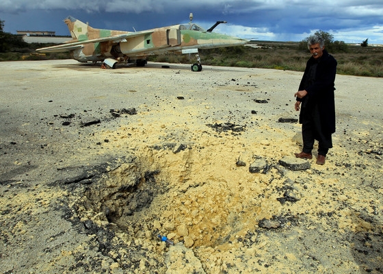 A man shows a crater caused by what he says is the impact of a missile fired © Private